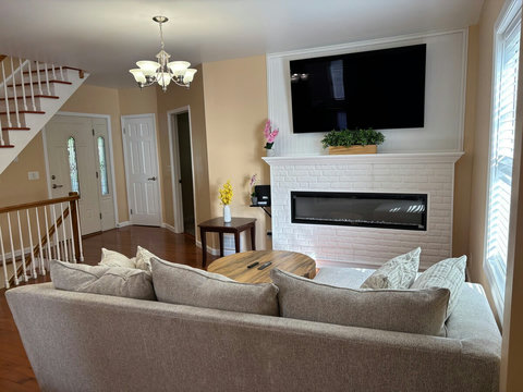Home Theater room with modern electric fireplace, coffee table, sleeper sofa, and 65-Inch ULED 4K Google TV to enjoy movies in the large screen.