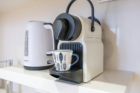 Fully equipped kitchen with appliances (fridge/freezer, dishwasher, microwave oven, toaster, coffee machine, kettle, and juicer).
