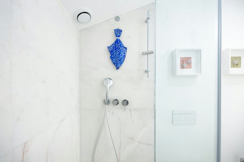 Marble bathroom with walk-in rain shower and 24-hour hot high-pressure water. Large mirror, hair dryer, free toiletries (shampoo, conditioner and body wash), high-quality branded towels, and heated towel rack are all included.