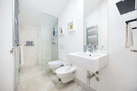 Marble bathroom with walk-in rain shower and 24-hour hot high-pressure water. Large mirror, hair dryer, free toiletries (shampoo, conditioner and body wash), high-quality branded towels, and heated towel rack are all included.