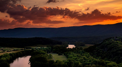 Sunset river valley views with rolling mountains and lush forests