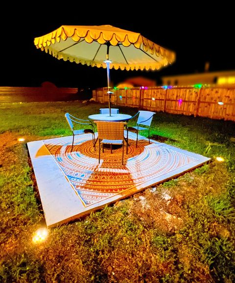 Outdoor Table with Umbrella & LED light for night dining. Fence with Post Lights