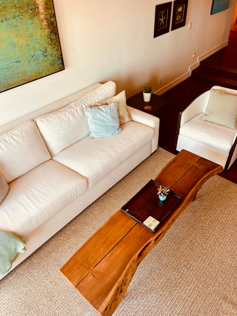 - Plush sofa beside a sculpted wood coffee table that doubles as a conversation piece
- Calming coastal tones & curated decor create a peaceful, elegant setting to unwind
- Ideal for morning reads, evening chats, or movie nights in comfort & style