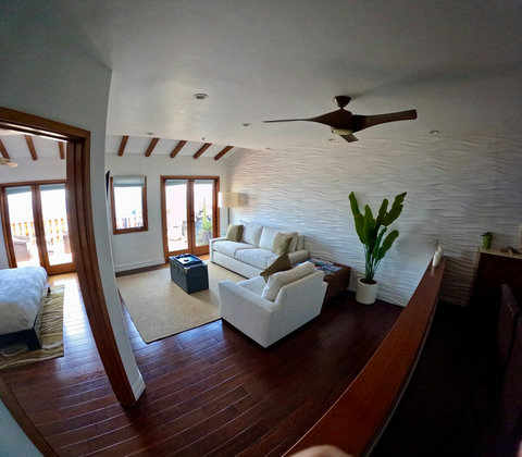 - Lounge in style with textured wave walls, plush white seating, and tropical vibes
- French doors open to your private balcony, letting ocean breezes roll through
- Vaulted ceiling with wood beams adds warmth to this breezy coastal haven