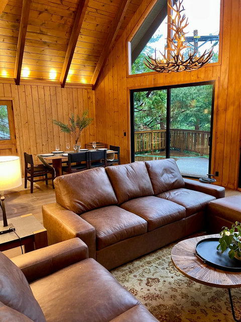 - Plush leather sofas under soaring vaulted ceilings and soft mood lighting
- Dine under a striking antler chandelier with views of the surrounding forest canopy
- Step onto the private deck through sliding glass doors for fresh air and nature sounds