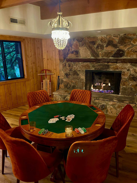 - Classic poker table for game night by the glow of a crackling stone fireplace
- Plush velvet chairs and a sparkling chandelier add a touch of vintage style to your play
- Enjoy cozy ambiance and forest views from this stylish lower level retreat