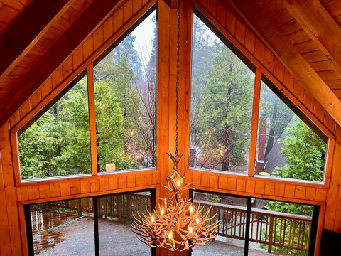 - Towering windows flood the cabin with natural light and frame the forest like art
- Watch the rain fall or snow drift from your perch above it all, nature’s show, uninterrupted
- Signature chandelier adds just the right touch of mountain drama to y
