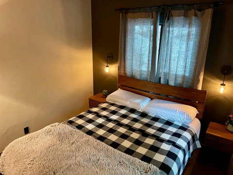 - Drift into comfort with a queen bed dressed in buffalo plaid & a plush faux fur throw
- Enjoy warm bedside pendant lighting, sleek wood furnishings, & a cozy window view
- Neutral tones & soft textures create a relaxing retreat for restful nights