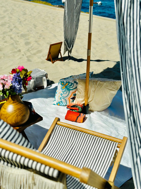 Soft pillows, floral touches, and breezy cabana shade create a dreamy beachside escape.