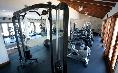 Fully equipped fitness center with cardio bikes, resistance machines, and mirrors to enhance your workout experience.