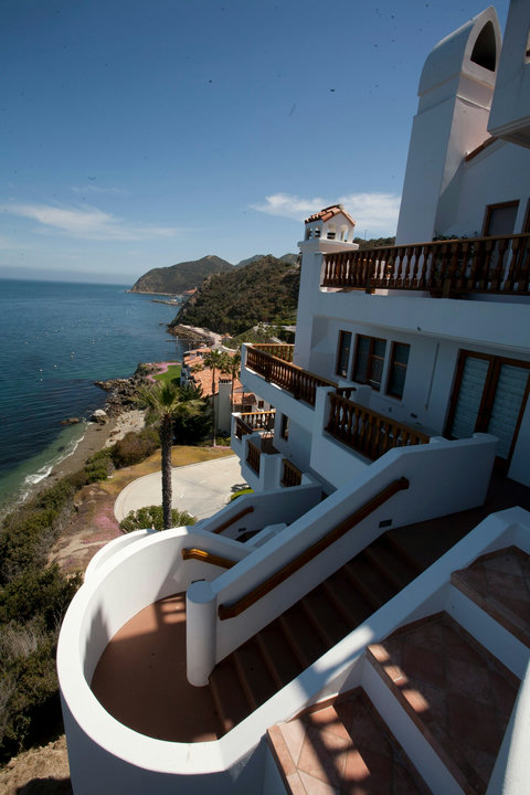 Whitewashed cliffside retreat with sweeping terraces and breathtaking ocean and mountain views.