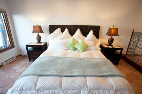 - Drift into comfort with fluffy white pillows, soft throws, and bright accent cushions
- Natural light filters through large windows for a fresh and airy start to your day
- Stylish nightstands with warm toned lamps set the mood for peaceful evening