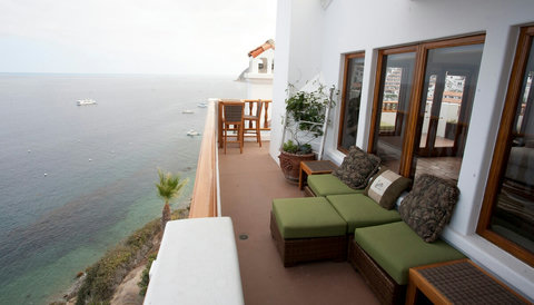 - Kick back on the coastal balcony with rattan loungers and soft green cushions
- Enjoy panoramic views of boats drifting along turquoise waters right below
- Cozy outdoor space perfect for cocktails, books, or sunset conversations