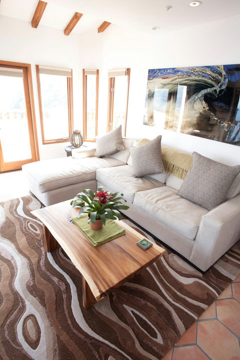 - Lounge in a naturally lit living room with tall windows and mountain view glimpses
- Sink into the plush sectional sofa with soft earth toned accents and cozy throws
- Vibrant centerpiece and wave inspired artwork add charm to your relaxing retreat