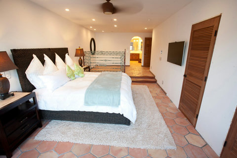 - Spacious master suite featuring a plush king bed and soft lighting
- Walk through to a private ensuite bath and enjoy the open plan layout with TV and lounge
- Elegant ironwork and terracotta floors add warmth and charm throughout the space