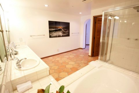 - Spacious ensuite with double sinks, glass shower, and plenty of counter space
- Thoughtfully styled with wave inspired art and warm terracotta tile flooring
- Extra lighting and mirrors create a fresh, polished start to your day