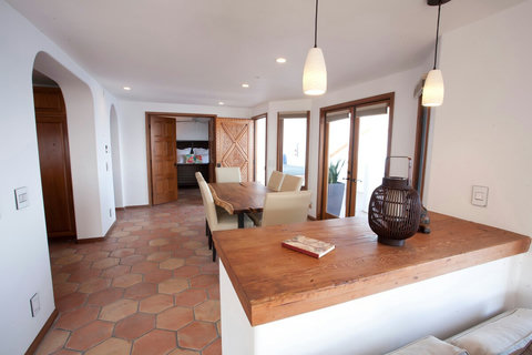 - Open concept dining area with artisan wood table and cushioned chairs for six
- Surrounded by large windows and arched doorways for a bright, breezy feel
- Seamless connection to the patio and guest room makes this the heart of the home