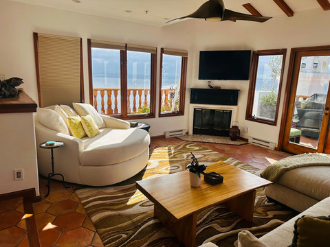 - Kick back in a cozy swivel lounger surrounded by sunshine and scenic ocean views
- Enjoy a movie night or fireside chat in this bright, inviting living space
- Thoughtful touches like throw pillows and textured rugs make this spot feel like home