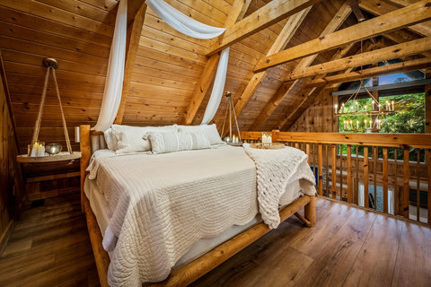 King size bed with 4 pillows and extras to spare. Comfort over everything! Hand built hanging side tables with battery candles set the mood! 