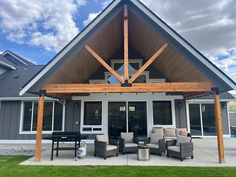 Covered back patio with Blackstone grill, wood fire pit, and plenty of seating