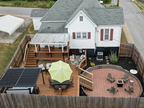 Private fenced backyard with covered deck dining, louvered pergola over hot tub, dining, game corner, cozy seating, firepit and propane heater