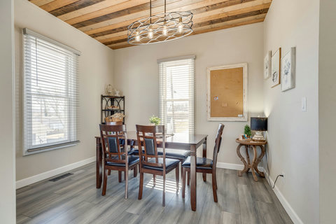 Bright dining room with wood-slat ceiling, chic lighting, and seating for 6.