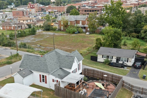 Aerial view of home with fenced backyard, deck, patio seating, and close to downtown