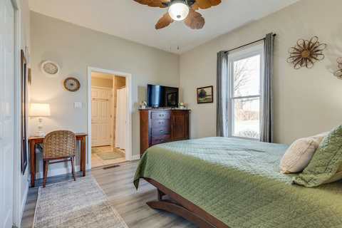 Primary bedroom with queen size bed, smart TV, dedicated workspace, and en suite bathroom.