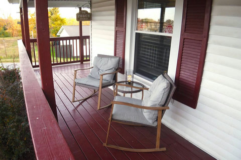 The charming front porch invites you to relax in the cozy rocking chairs, creating an idyllic setting to unwind and take in the surroundings.