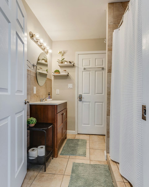 Bright, tiled bath with walk-in shower with all the essentials to start your stay.