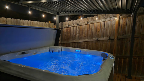 Private covered hot tub with ambient lighting and spa-like vibes