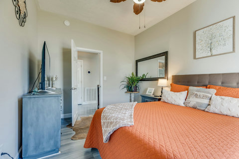 Cozy bedroom with plush bed, TV, ceiling fan, and stylish decor