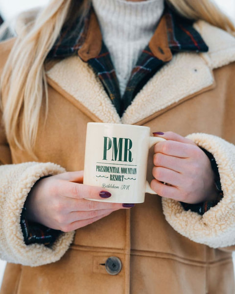 Cozy up with a warm drink in a rustic shearling jacket at presidential mountain resort.
