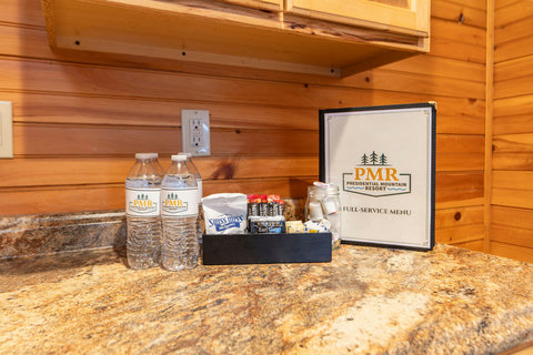 A rustic kitchen countertop with complimentary bottled water, coffee supplies, and a full-service menu from presidential mountain resort.