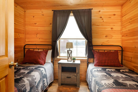 Cozy rustic bedroom with twin beds and woodland-themed bedding.