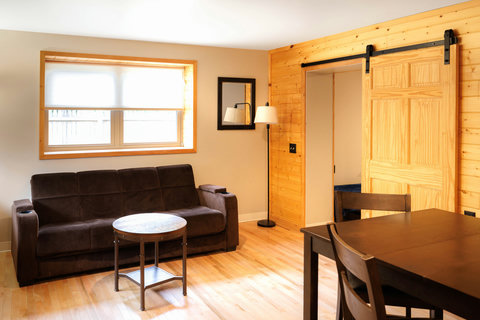 Cozy living area with a dark sofa, round coffee table, and sliding wooden barn door.