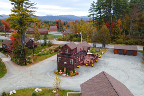 Rustic cabin with a spacious deck surrounded by autumn foliage and mountain views.