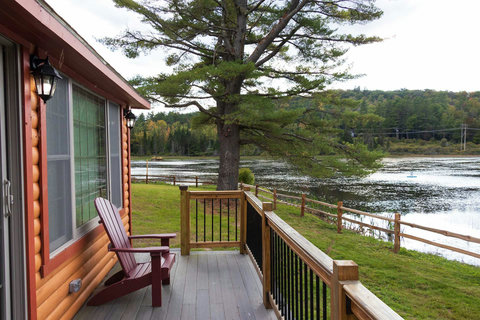 Relax on the rustic deck overlooking the peaceful lake and surrounding forest.