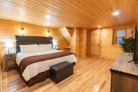 Cozy bedroom with wood-paneled walls and a king-size bed for a comfortable stay.