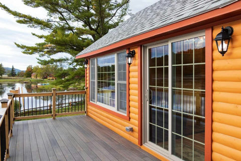 Relax on the spacious deck of this rustic lakeside cabin with scenic water views.