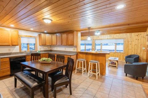 Cozy kitchen and dining area with wood-paneled walls and a view of the lake.