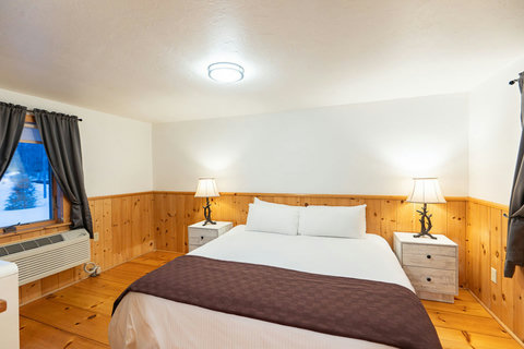 Cozy bedroom with wood paneling and soft lighting for a restful stay