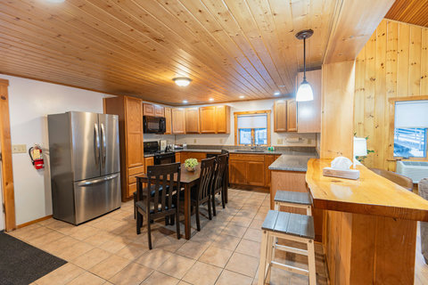 rustic kitchen with wooden cabinetry, a dining table, and a breakfast bar with stools