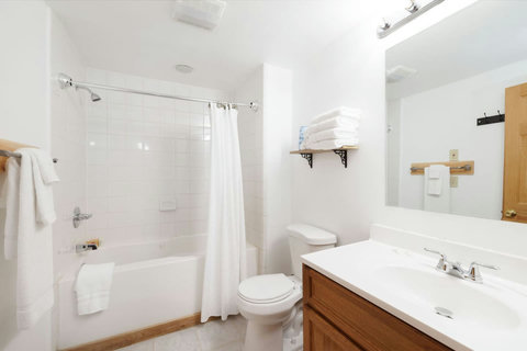 Clean and functional bathroom with a bathtub and ample towel storage.