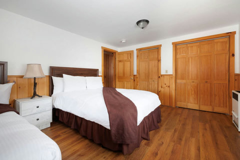 Cozy bedroom featuring wood accents and two comfortable beds with white linens.
