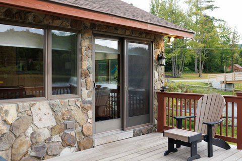 Rustic stone exterior with a relaxing deck chair overlooking a peaceful natural setting.