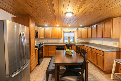 Spacious kitchen with wooden cabinetry and a dining table for family meals.