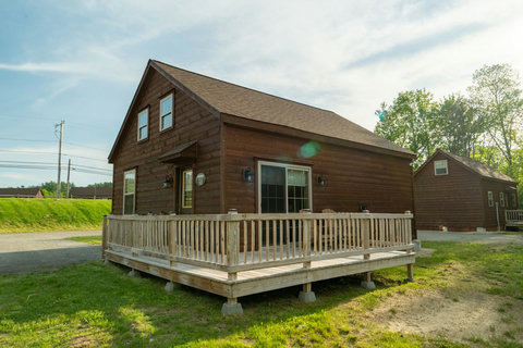 Rustic cabin with a spacious wraparound deck perfect for relaxing outdoors.