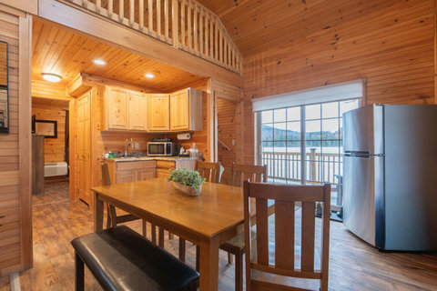 Cozy rustic dining area with a view of the outdoor deck and surrounding nature.