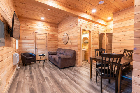 cozy living and dining area with wood-paneled walls and modern flooring